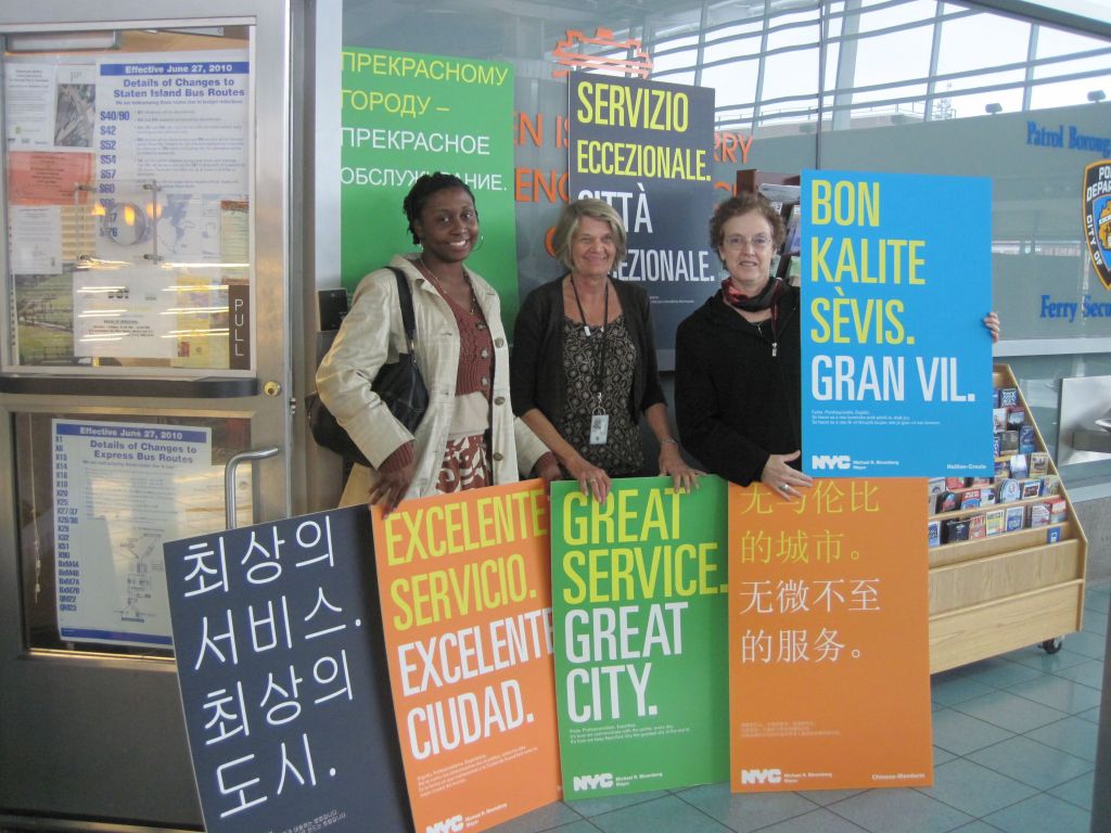 A group of people standing in front of a sign
Description automatically generated